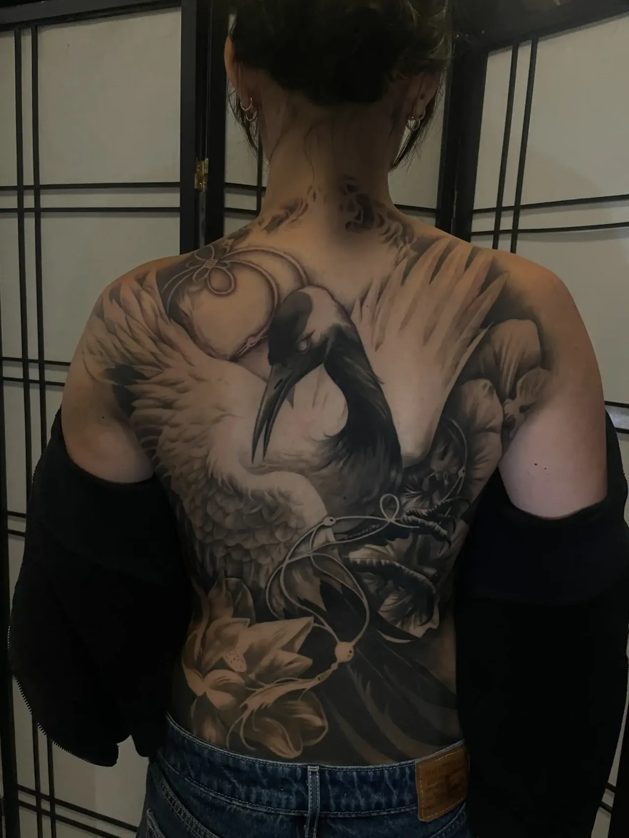 Large black-and-grey crane and floral backpiece.