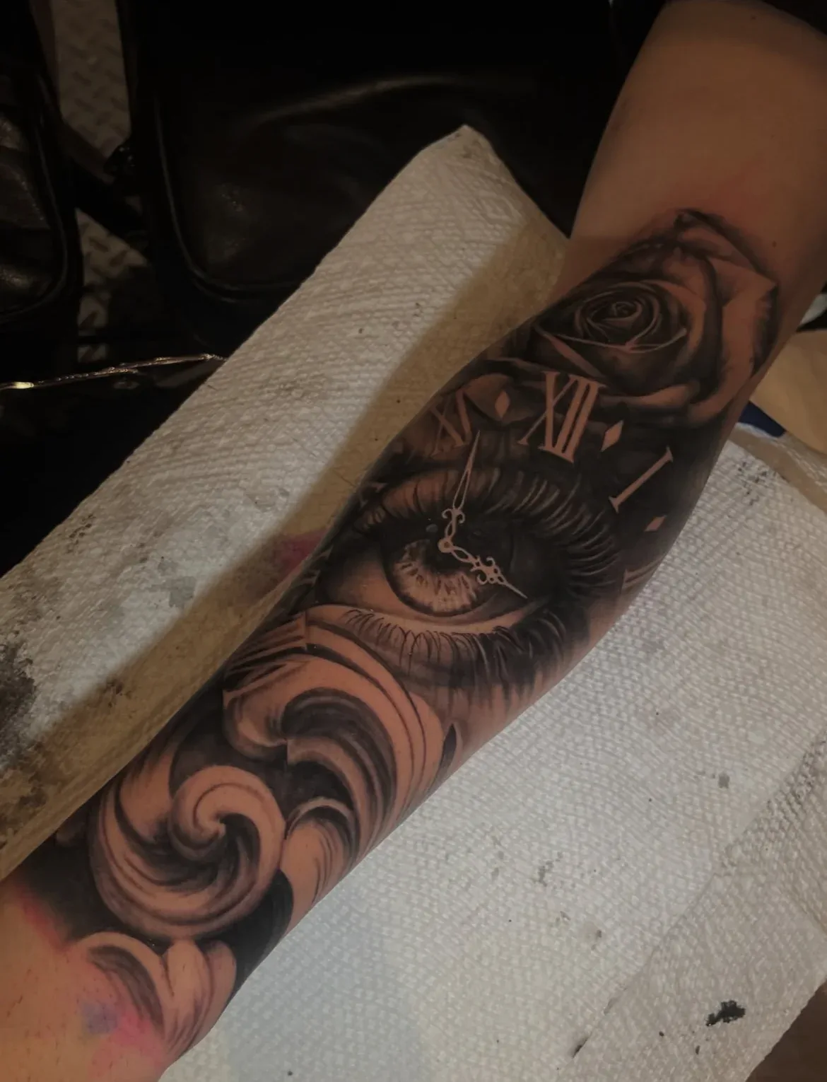 Black-and-grey eye, clock, rose and waves.