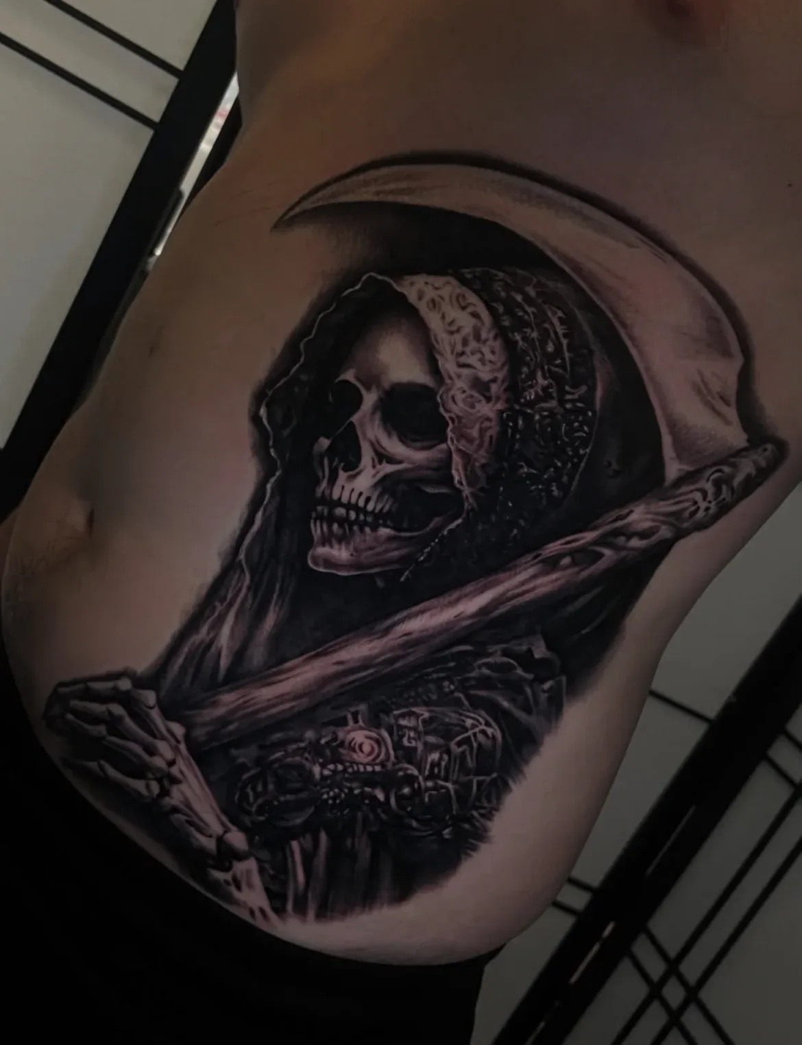 Black-and-grey grim reaper tattoo.
