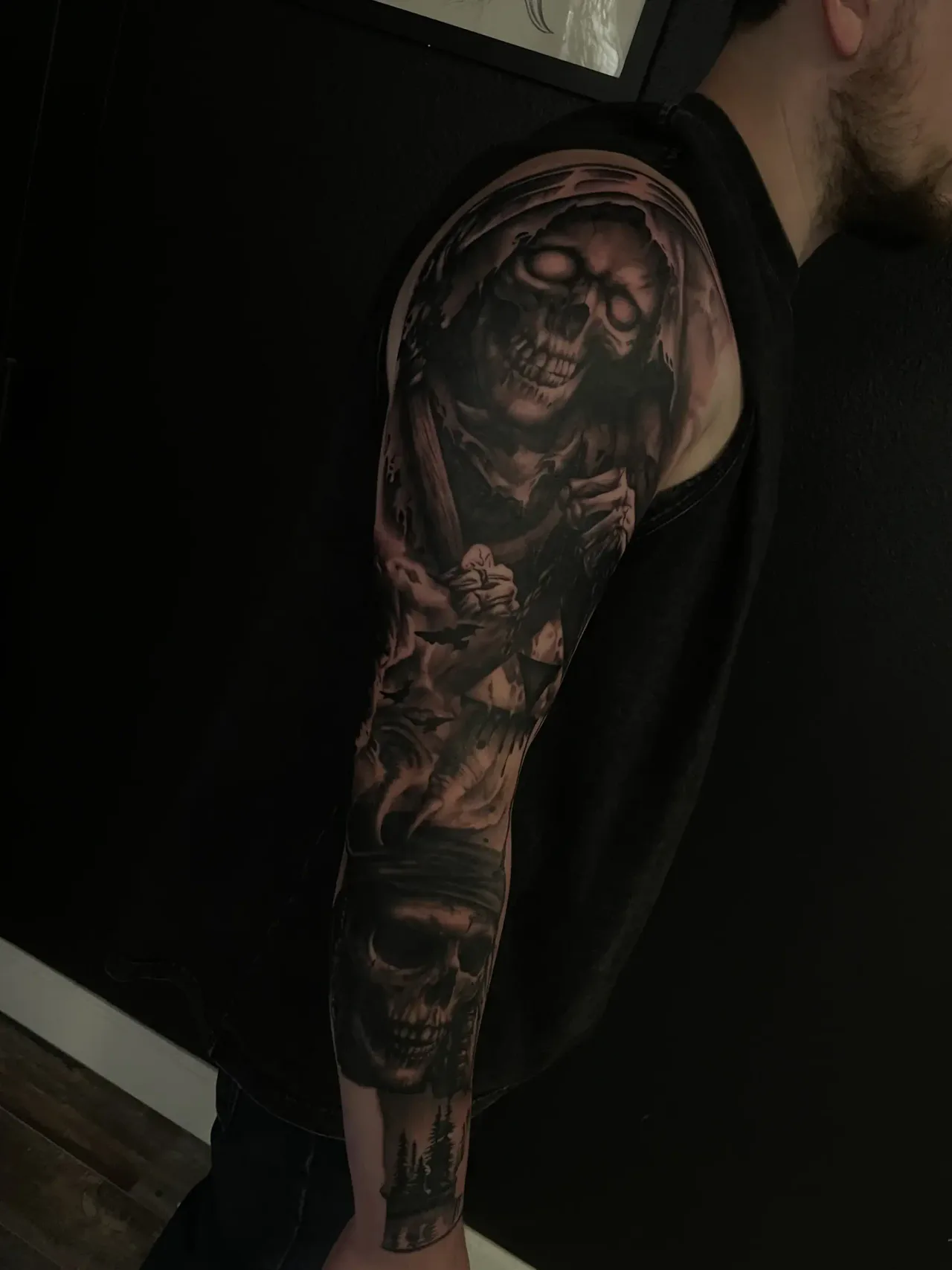 Dark black-and-grey hooded skull sleeve.