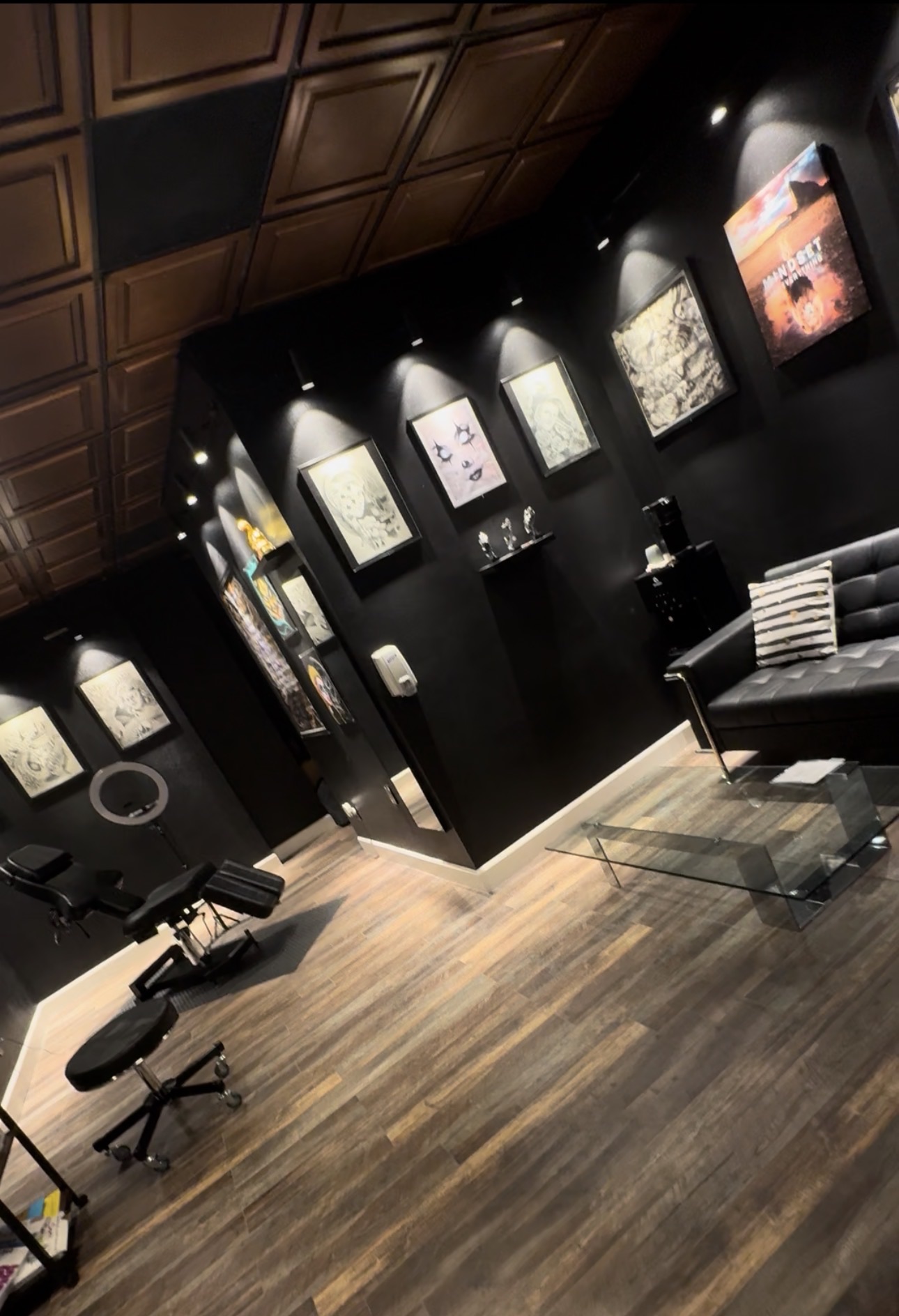 Wide interior view of Tattoo Nerds with black gallery walls and dedicated tattoo stations